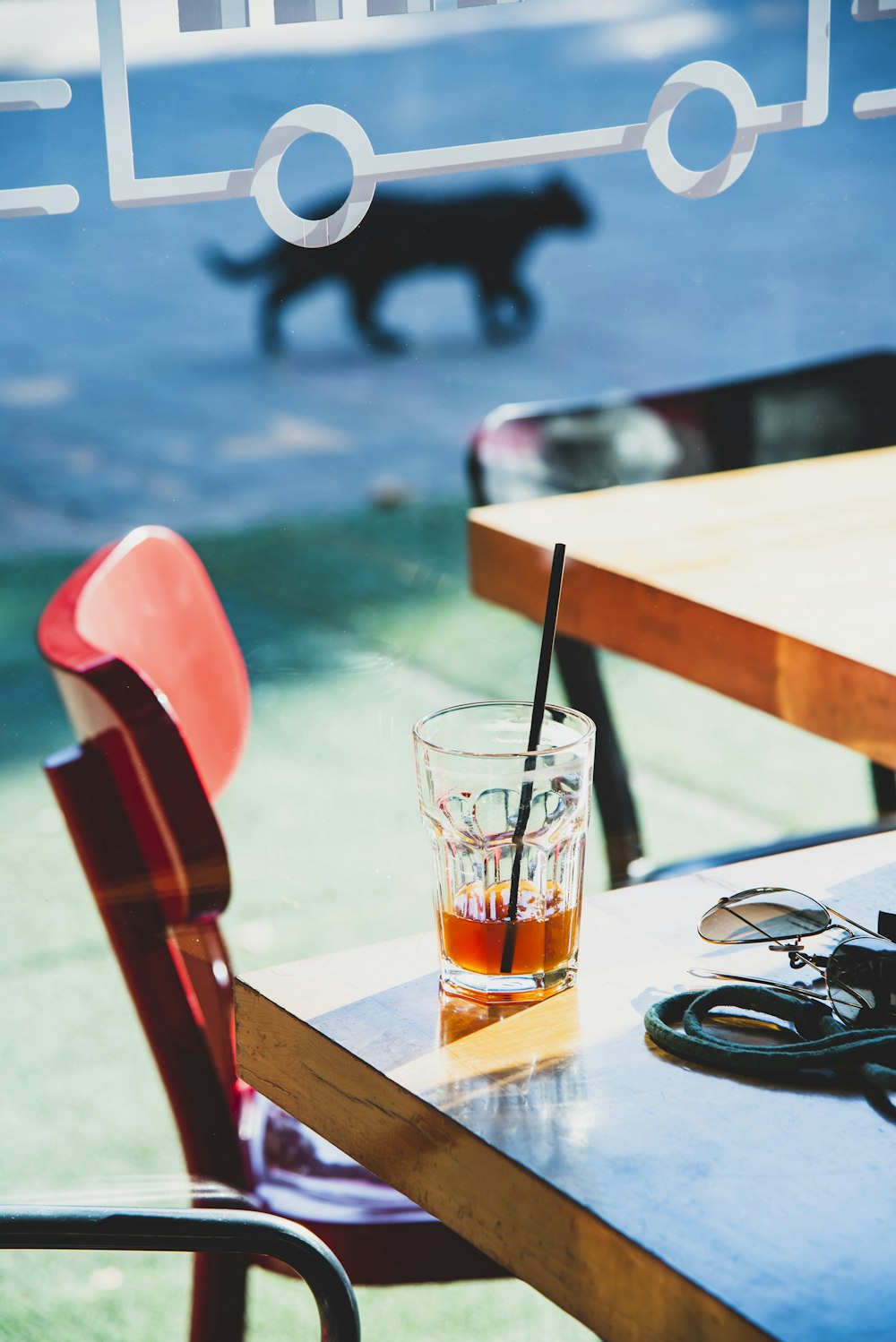 a glass of alcohol sitting on top of a wooden table