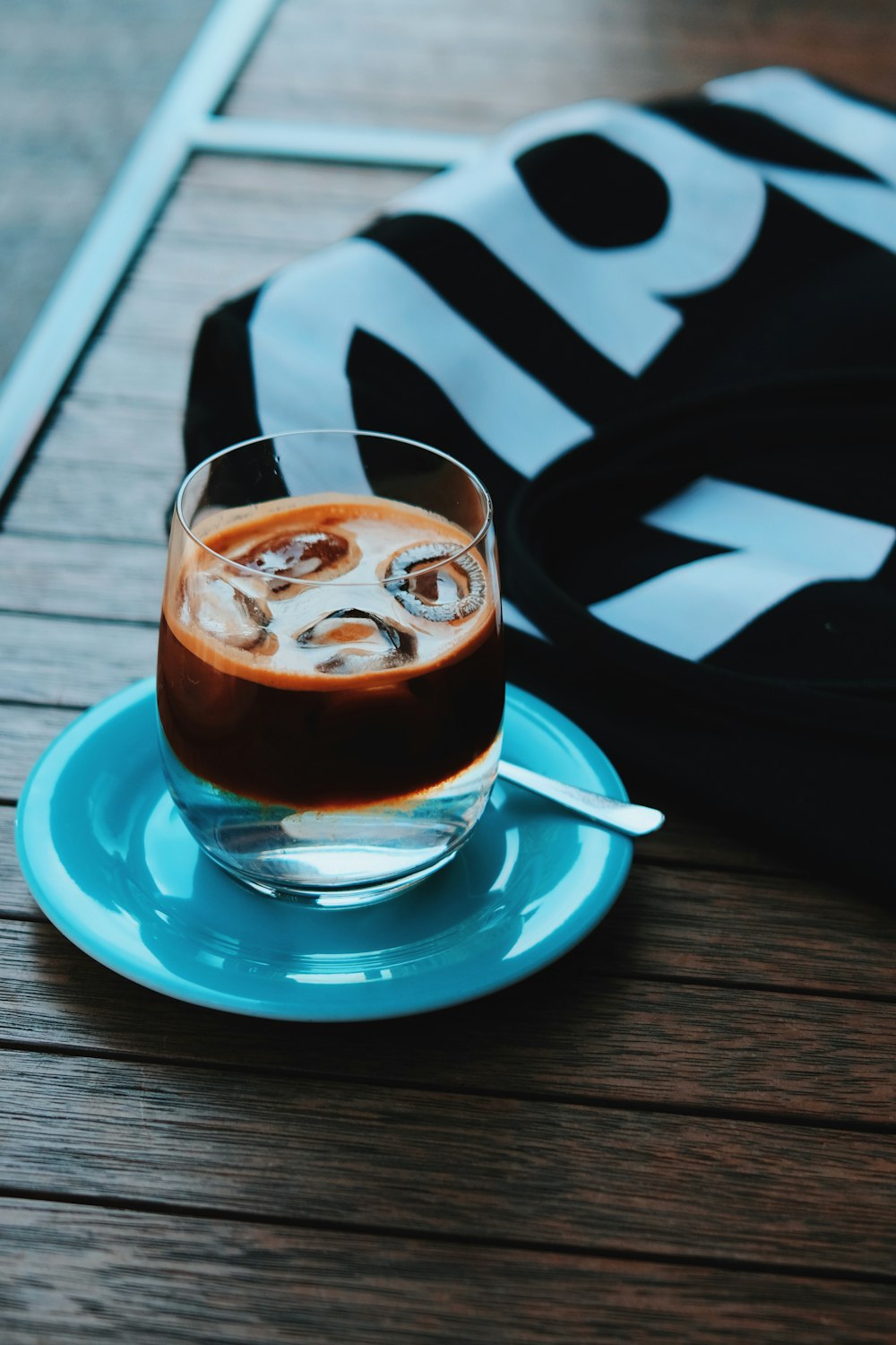 a glass of liquid sitting on top of a blue plate