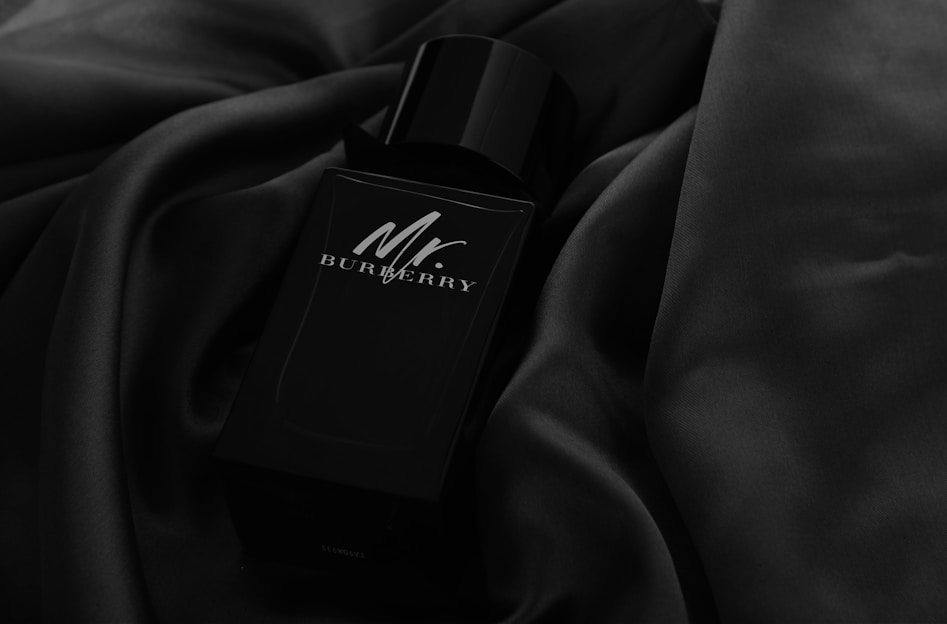 A sleek black perfume bottle on a marble surface.