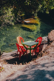 a couple of red chairs sitting next to a green table