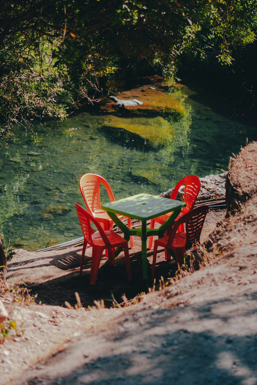 a couple of red chairs sitting next to a green table