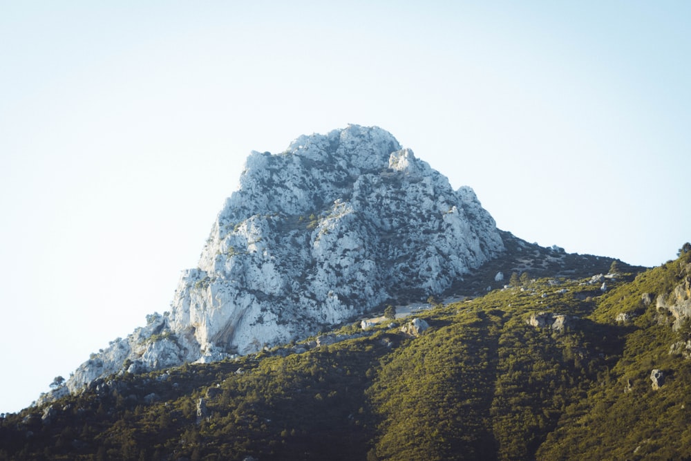 a very tall mountain covered in snow on a sunny day