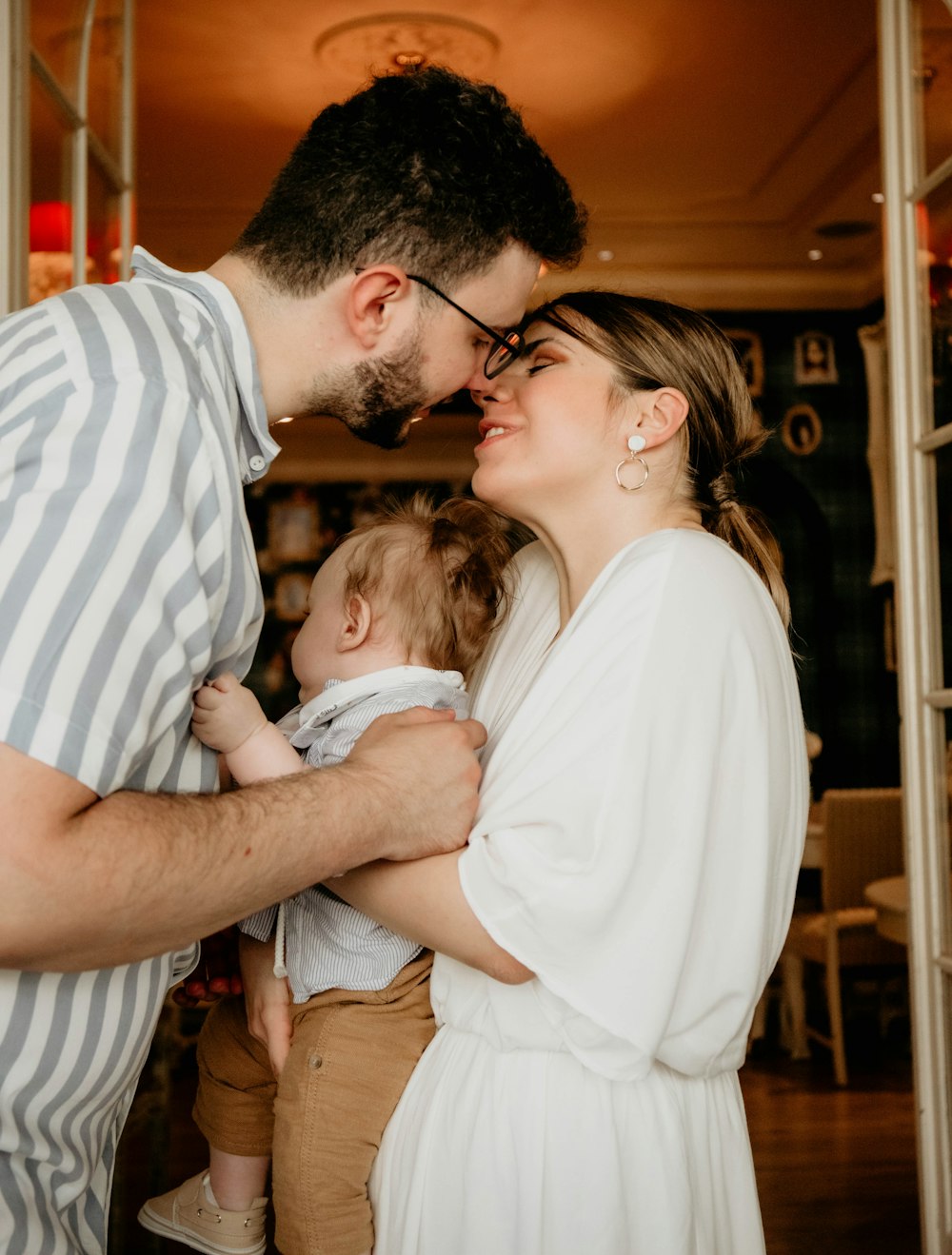 a man and woman holding a baby in their arms