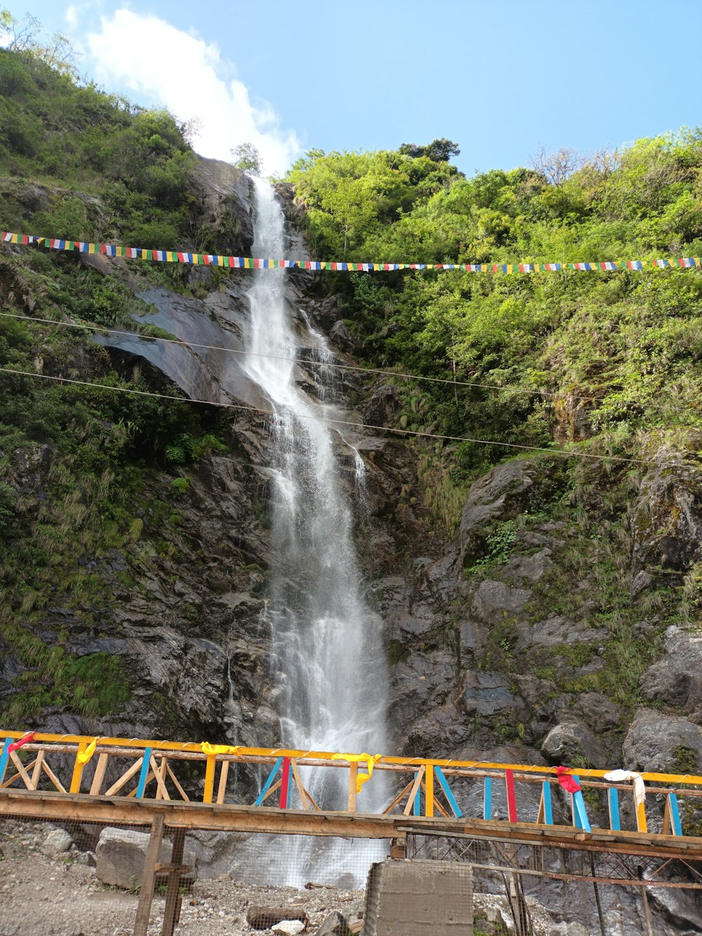 a large waterfall with a bridge over it