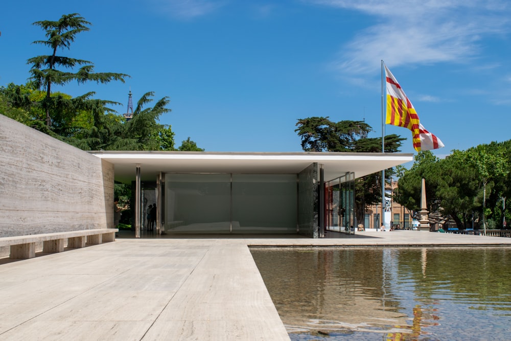 un edificio con una bandera encima junto a un cuerpo de agua