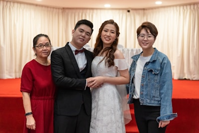 A group posing together inside a vogue photo booth framed by elegant drapes.