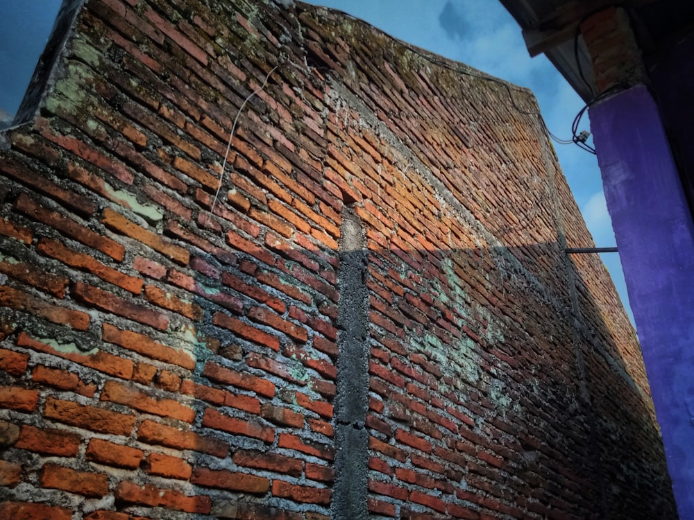 a brick wall with a street sign on it