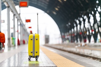 a yellow piece of luggage sitting on top of a tiled floor