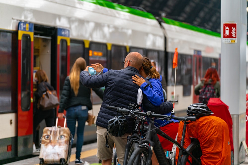 a couple of people standing next to a train