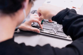 a woman is working on a laptop with her hands
