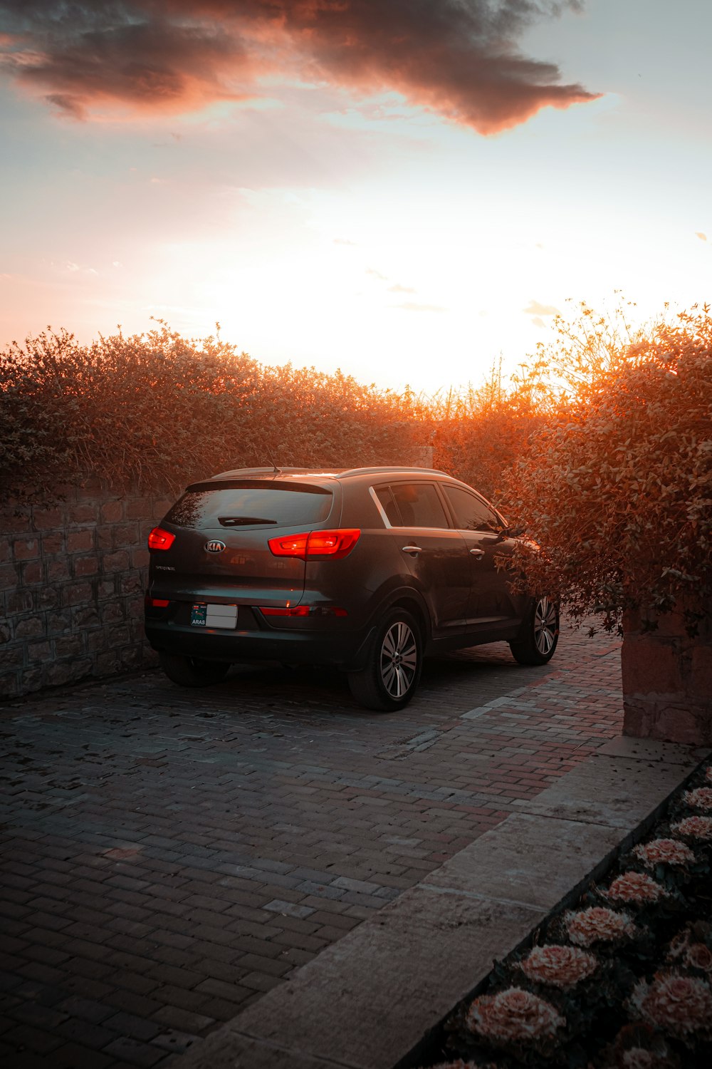 Un coche está aparcado en un camino de entrada al atardecer