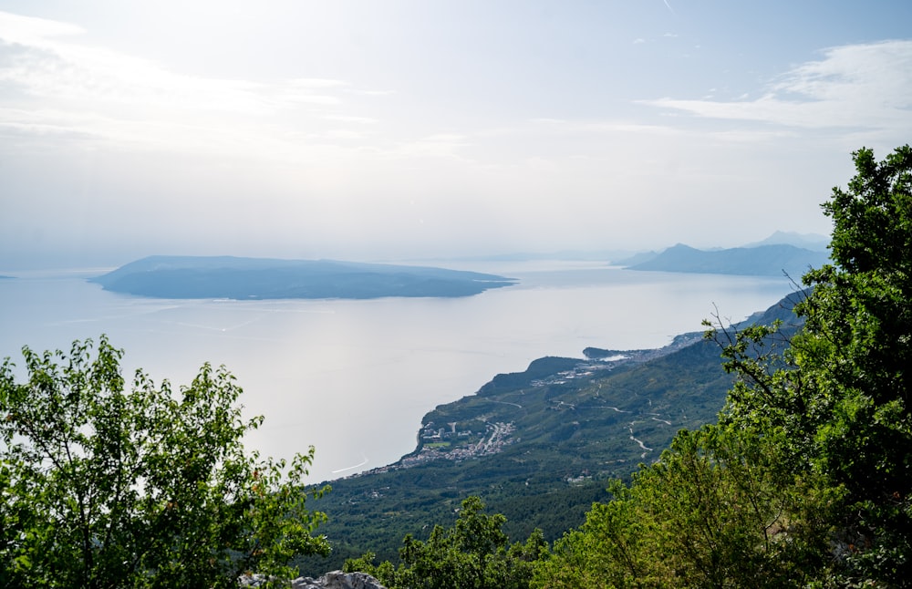 a view of a lake and mountains from a hill