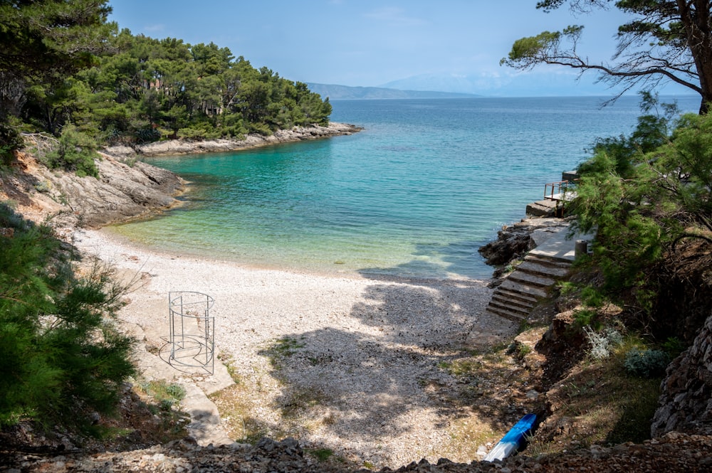 a sandy beach with steps leading to the water