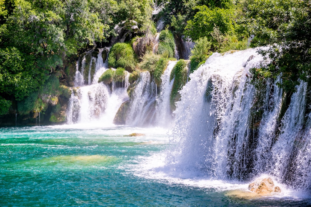 a large waterfall in the middle of a body of water