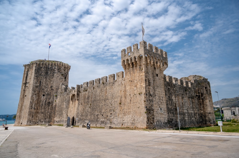 a large stone castle with a flag on top of it