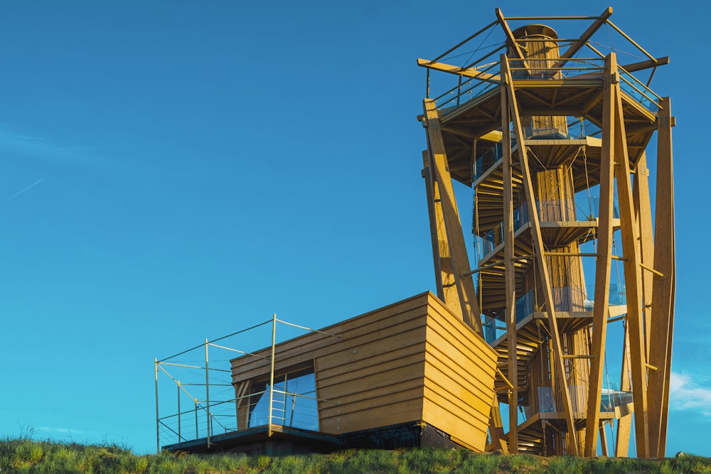 a tall wooden tower sitting on top of a lush green hillside