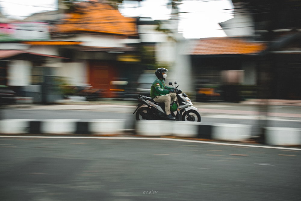 a man riding a motorcycle down a street