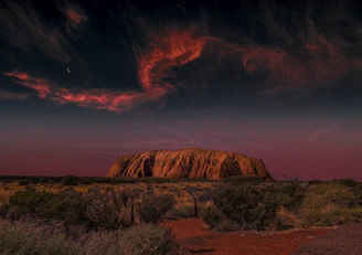 a large rock in the middle of a desert