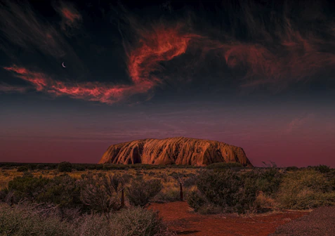 a large rock in the middle of a desert