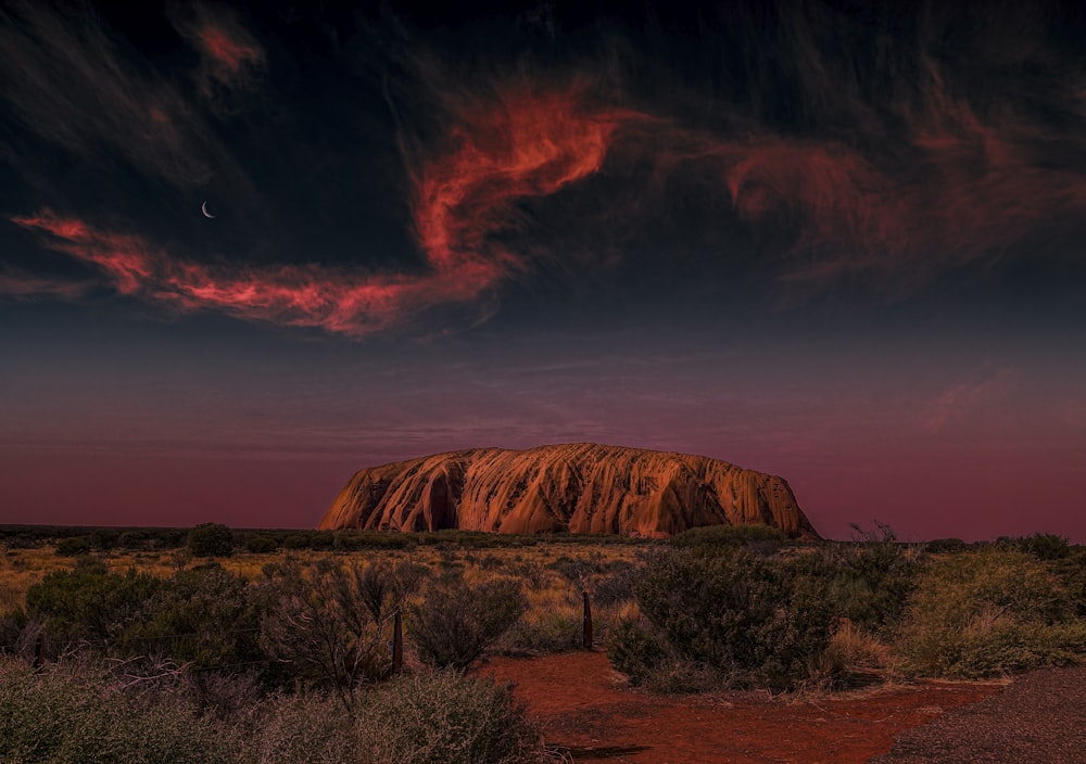 a large rock in the middle of a desert