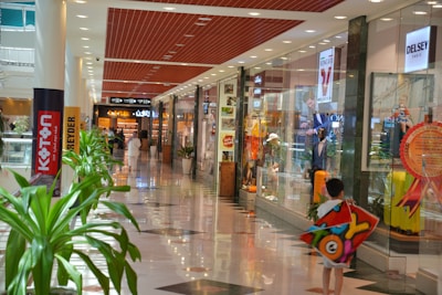 a young boy is holding a toy in a mall