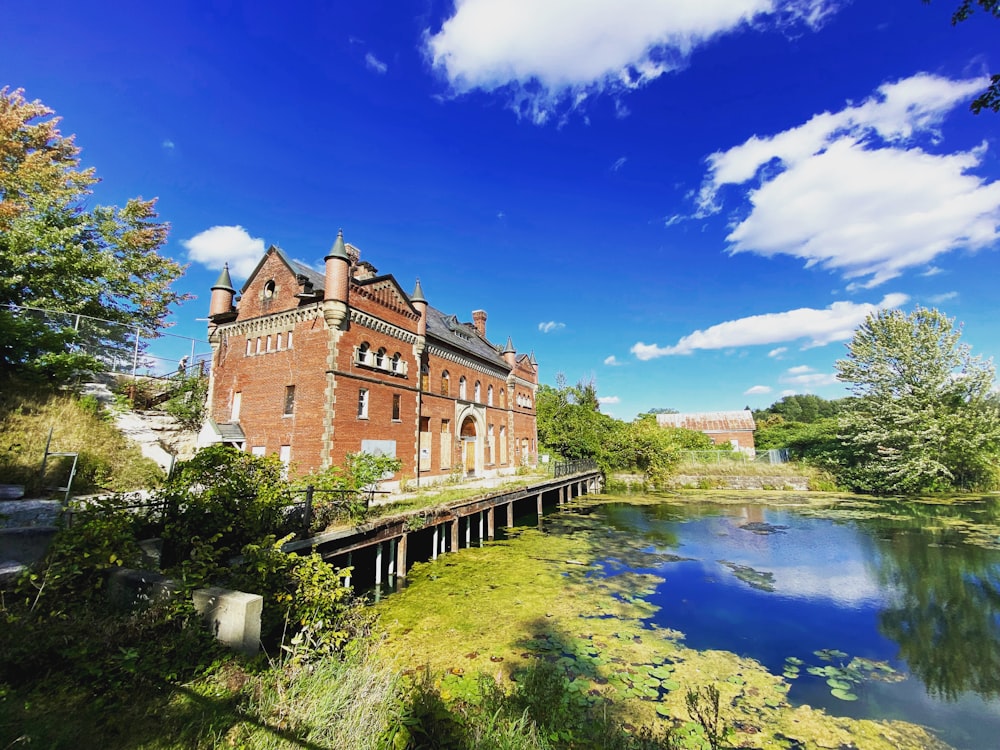 a large brick building next to a body of water