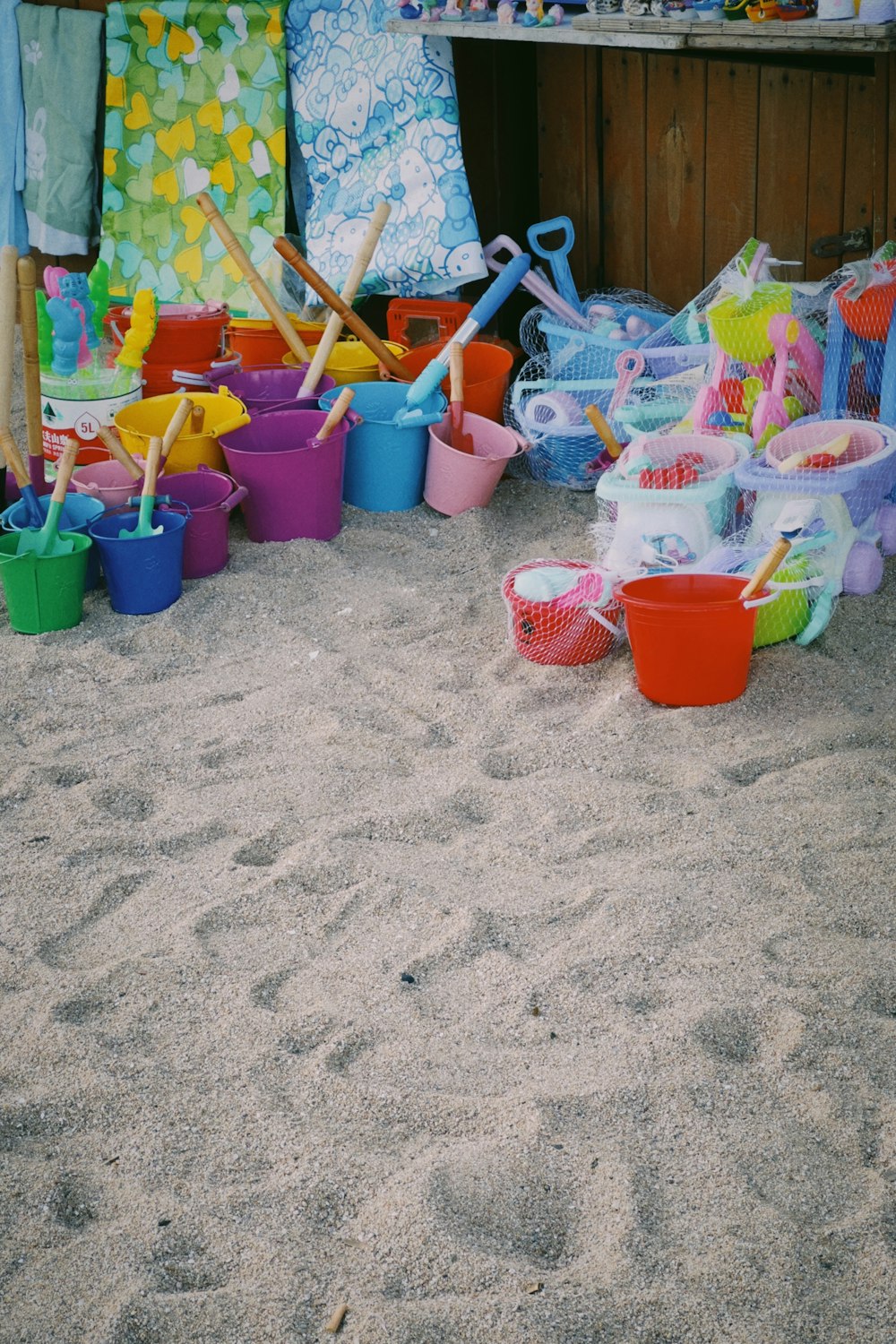 a bunch of buckets and shovels in the sand