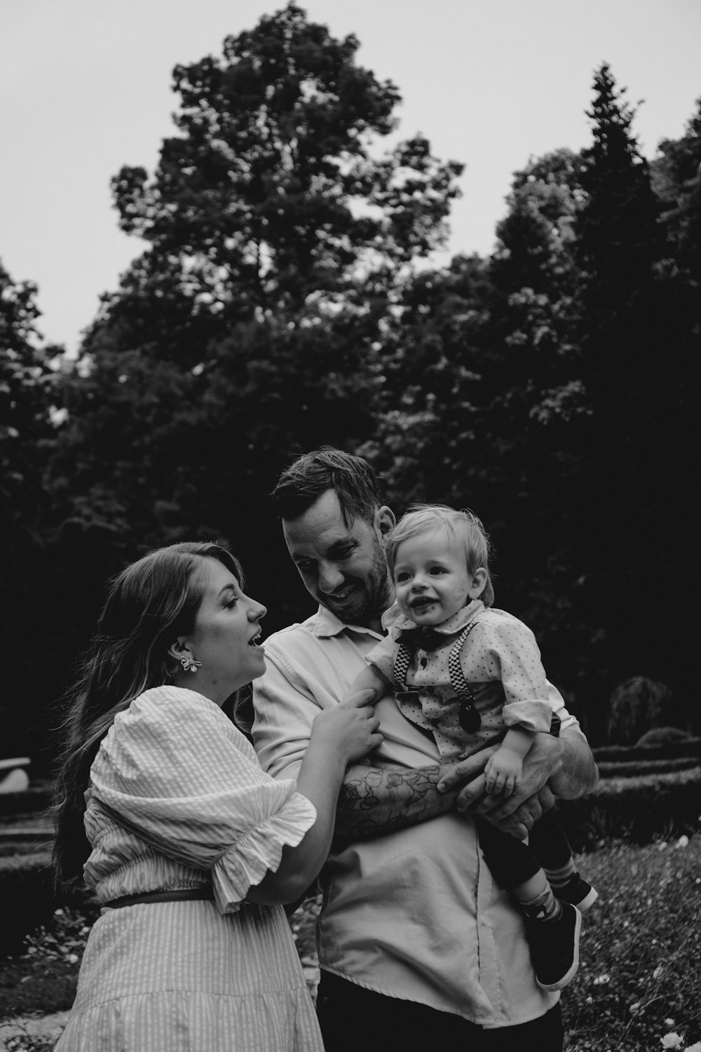 a black and white photo of a man and woman holding a baby