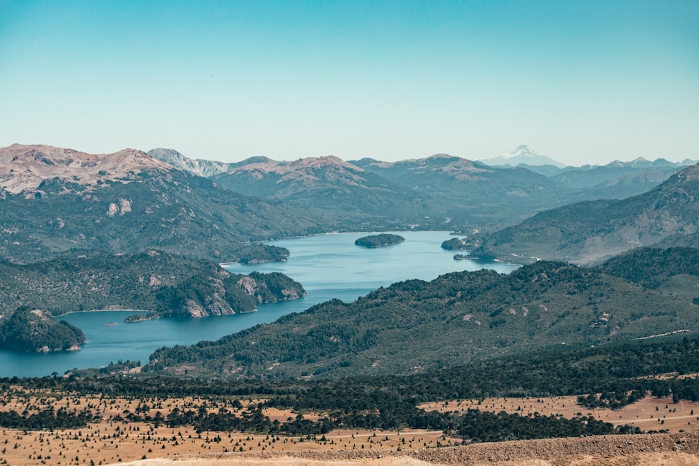 a scenic view of a lake surrounded by mountains