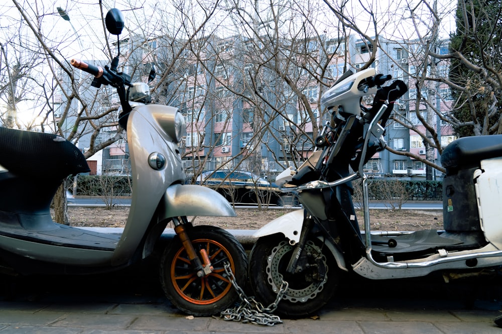 a scooter parked next to a scooter on a sidewalk