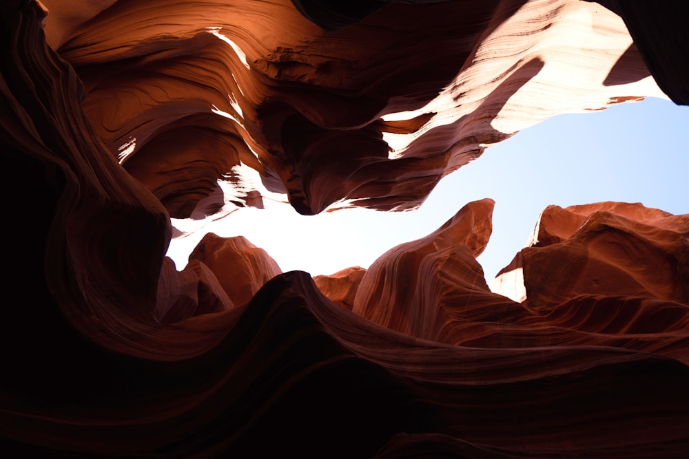 a view looking up into the sky through a slot in a rock formation