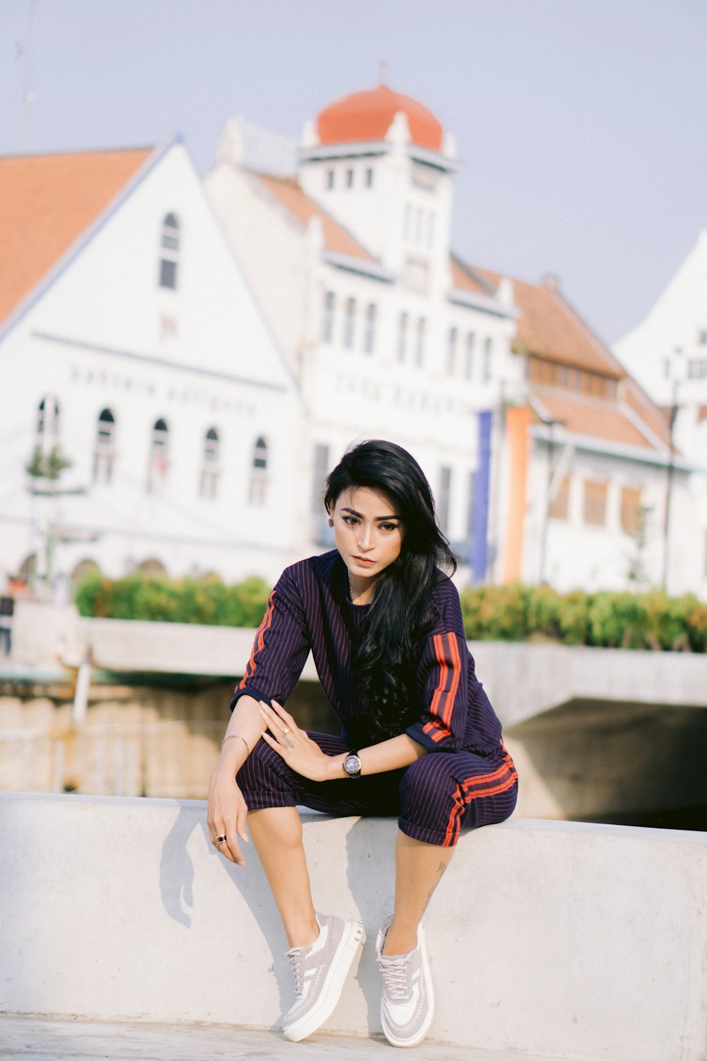 a woman sitting on a ledge in front of a building