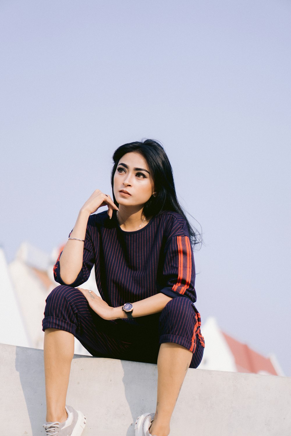 a woman sitting on top of a cement wall