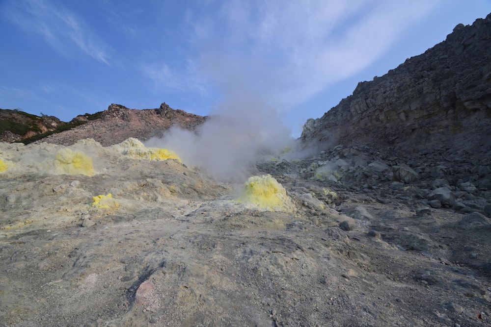 a view of a mountain with yellow smoke coming out of the ground