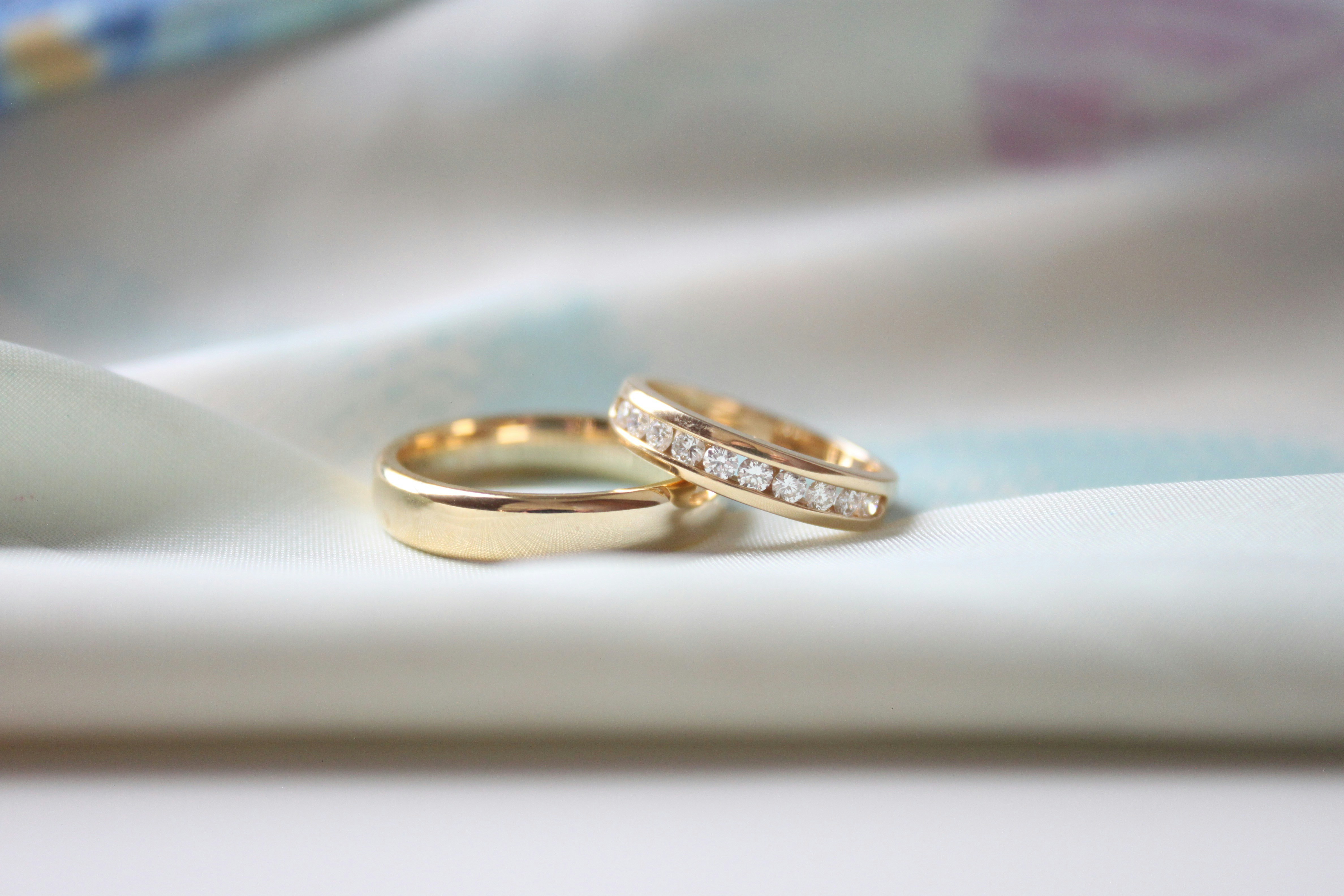 two wedding rings sitting on top of a white cloth