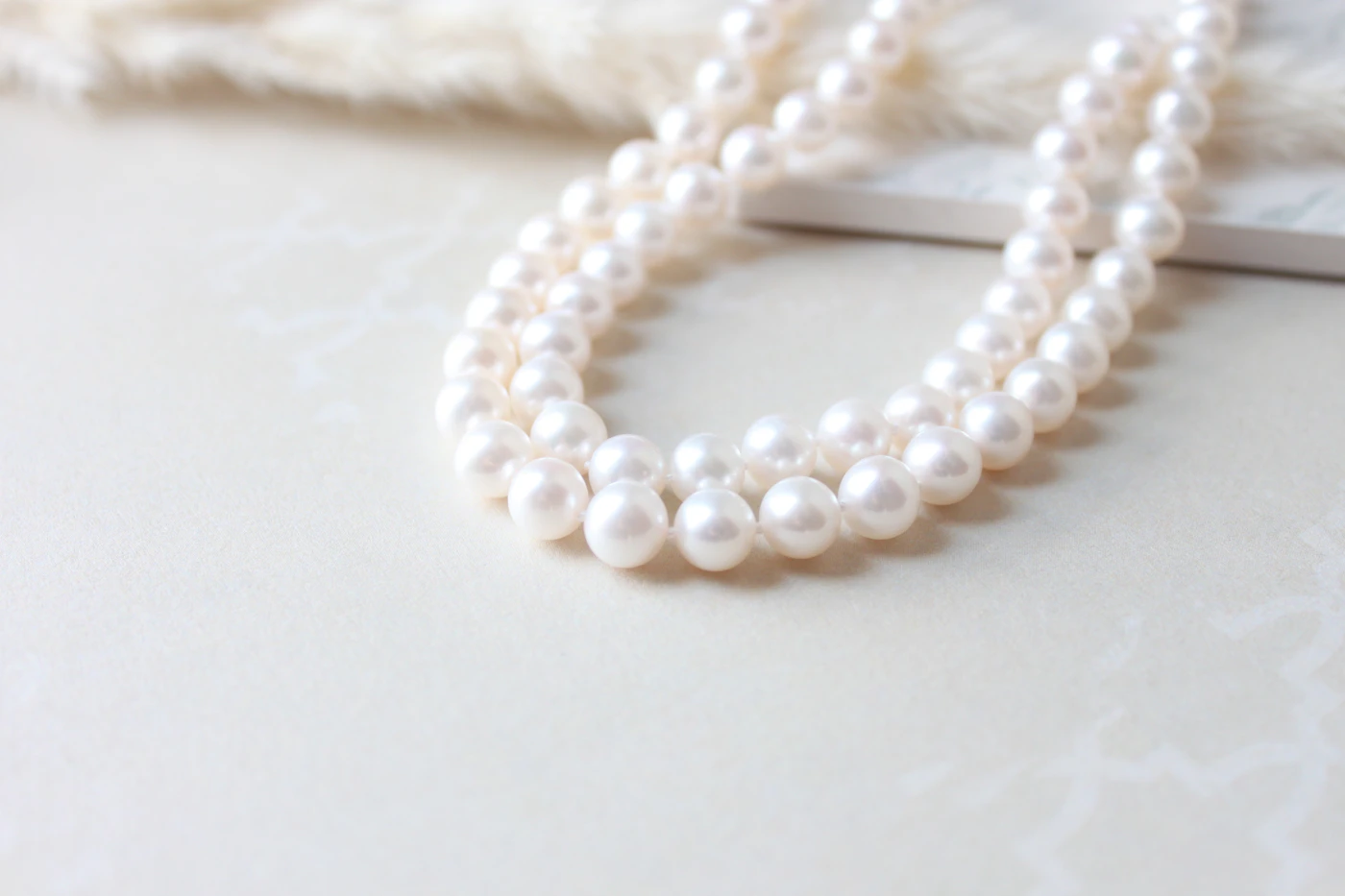 Close-up of a strand of white pearls showing luster and slight surface variation