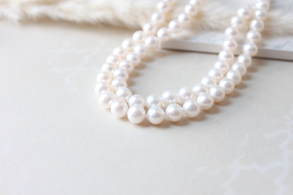 a close up of a necklace with pearls