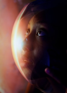 A close-up of a space helmet reflecting a distant planet and stars