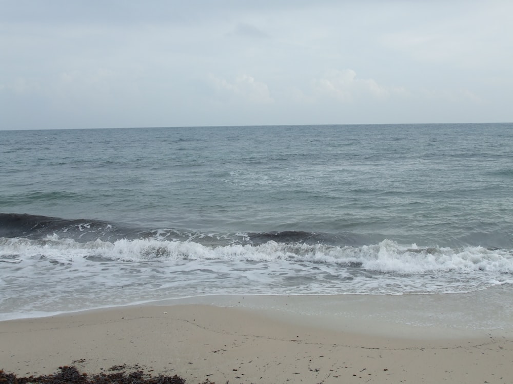 a body of water sitting next to a sandy beach