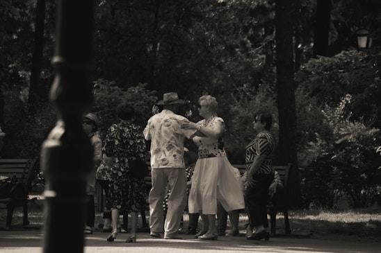 Smiling elderly people playing and dancing together in a bright, spacious community room