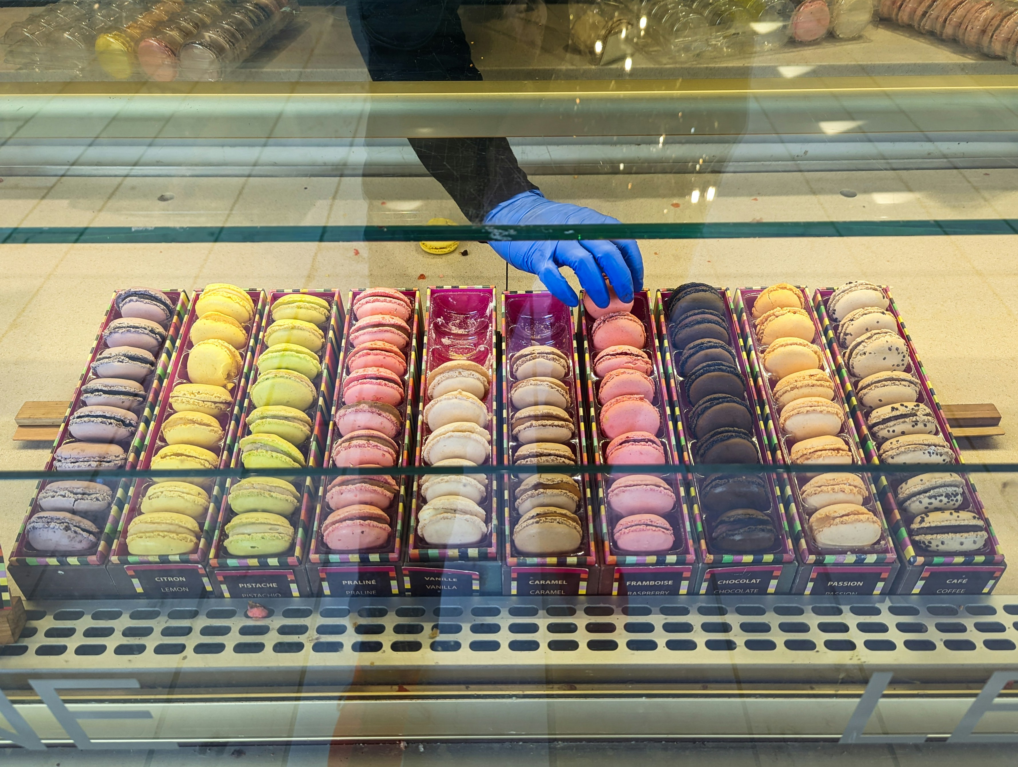 a display case filled with lots of different colored donuts