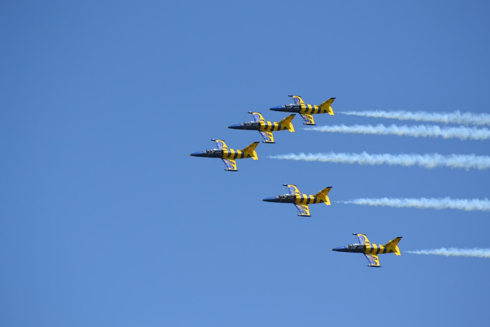 a group of fighter jets flying through a blue sky