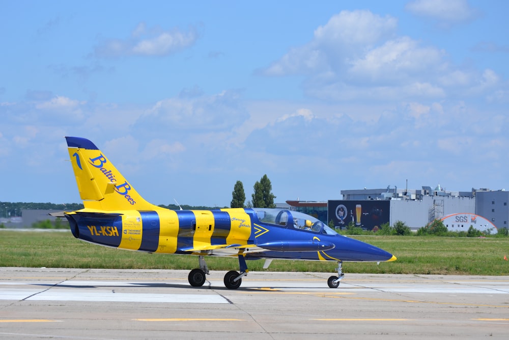 a small blue and yellow plane on a runway