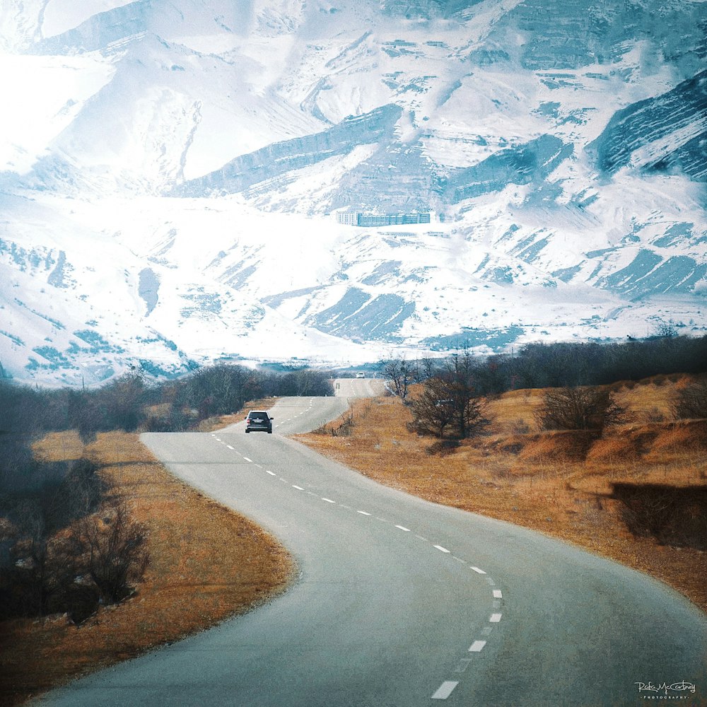 a car driving down a road in the mountains