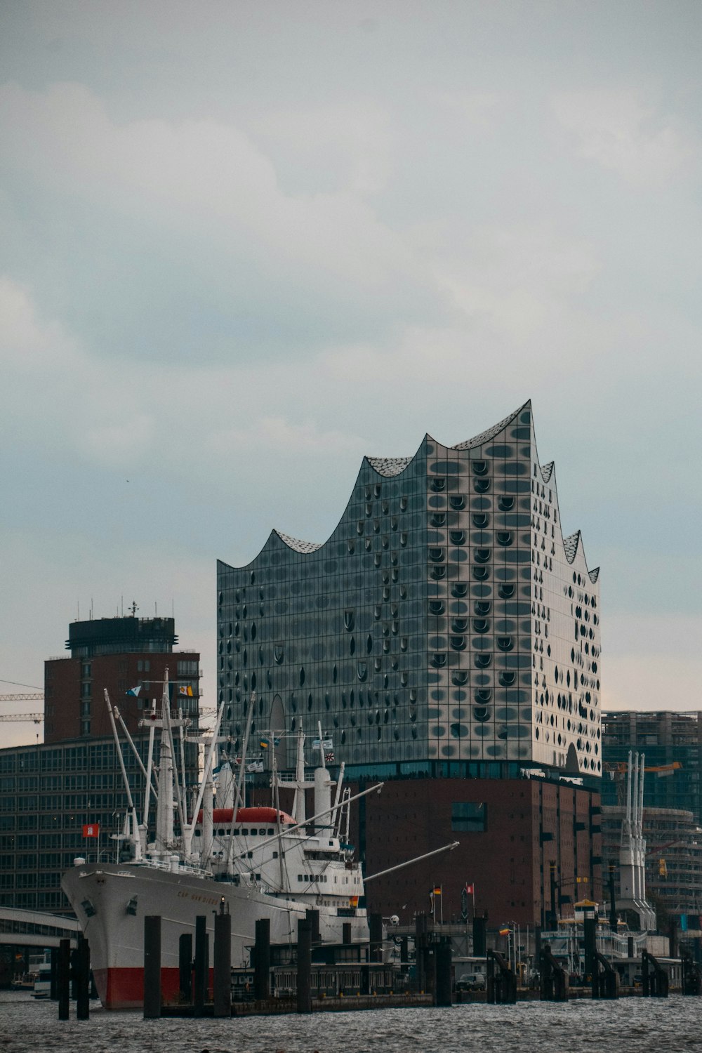 a large white boat sitting in a harbor next to a tall building