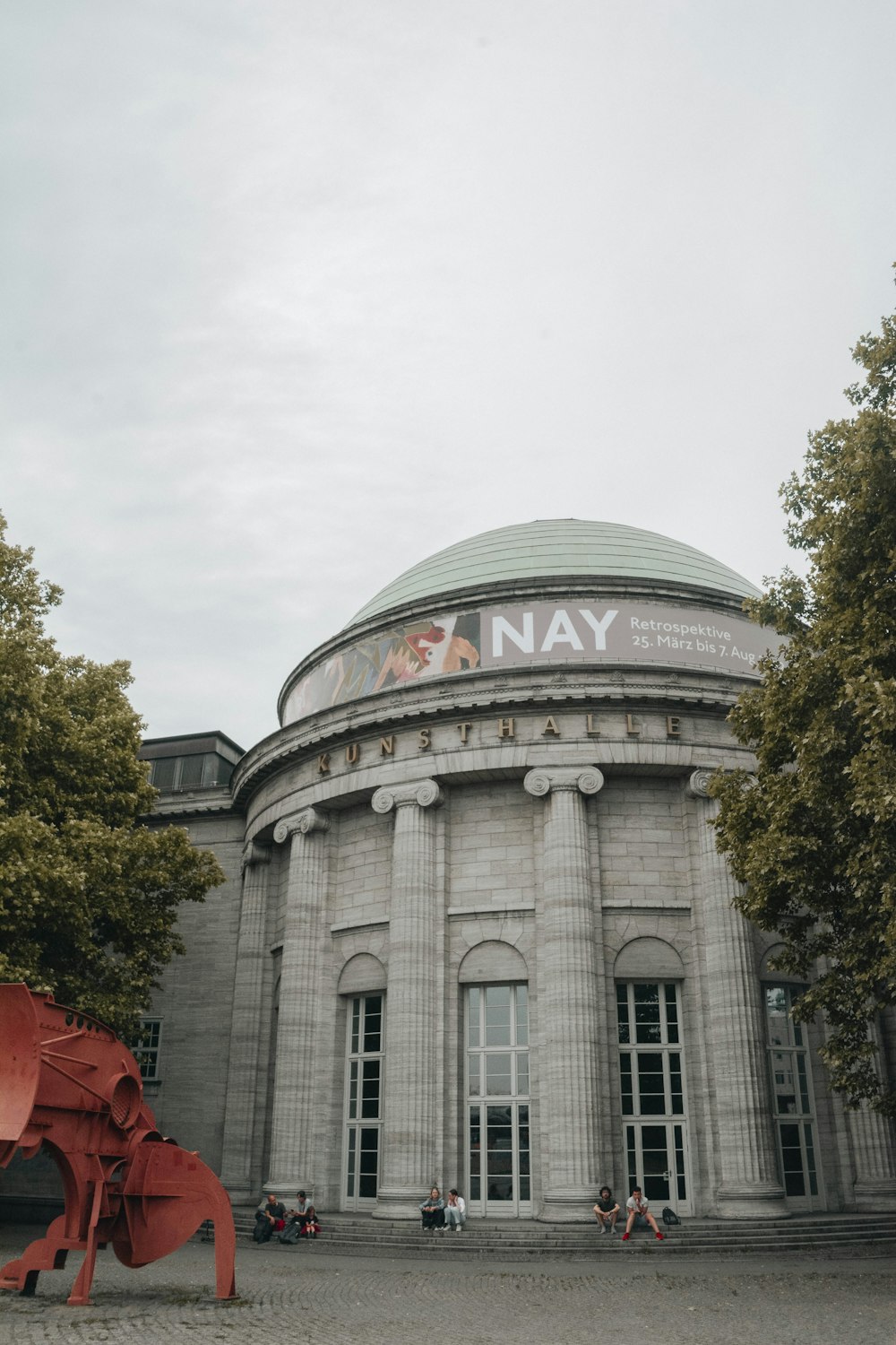 a large building with a giant red object in front of it