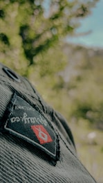 Close-up of a colorful embroidered scout patch featuring mountains and a campfire.