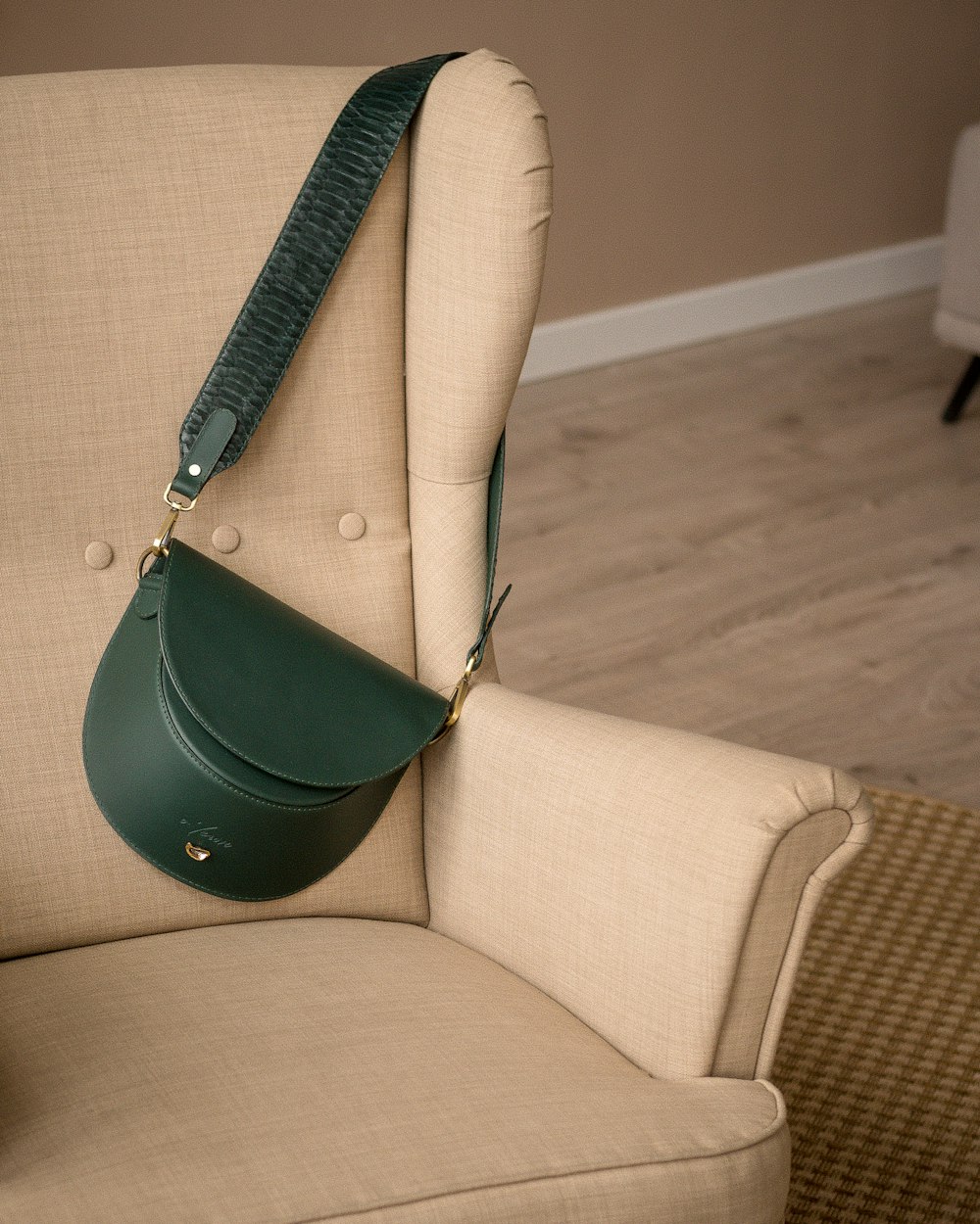 a green purse hanging from the back of a chair