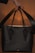 A stylish handbag displayed on a wooden table with soft natural lighting.