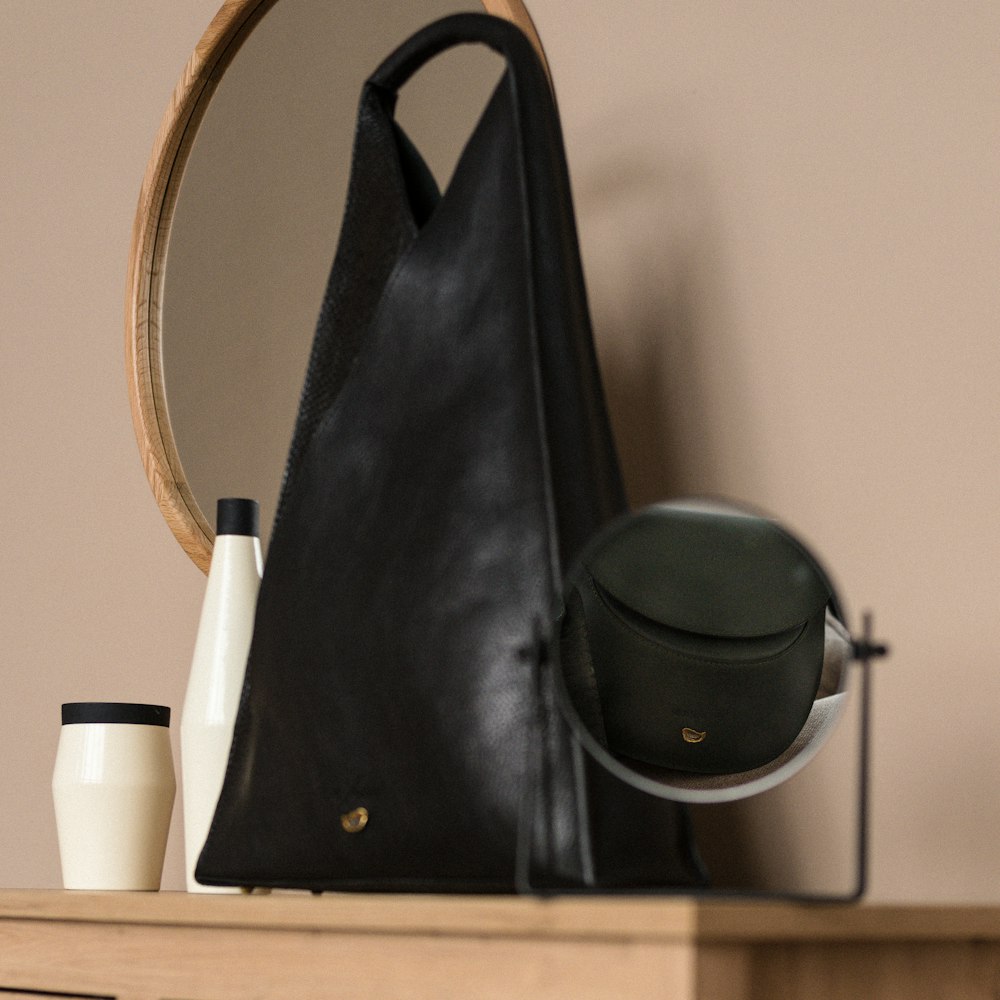 a black purse sitting on top of a wooden table